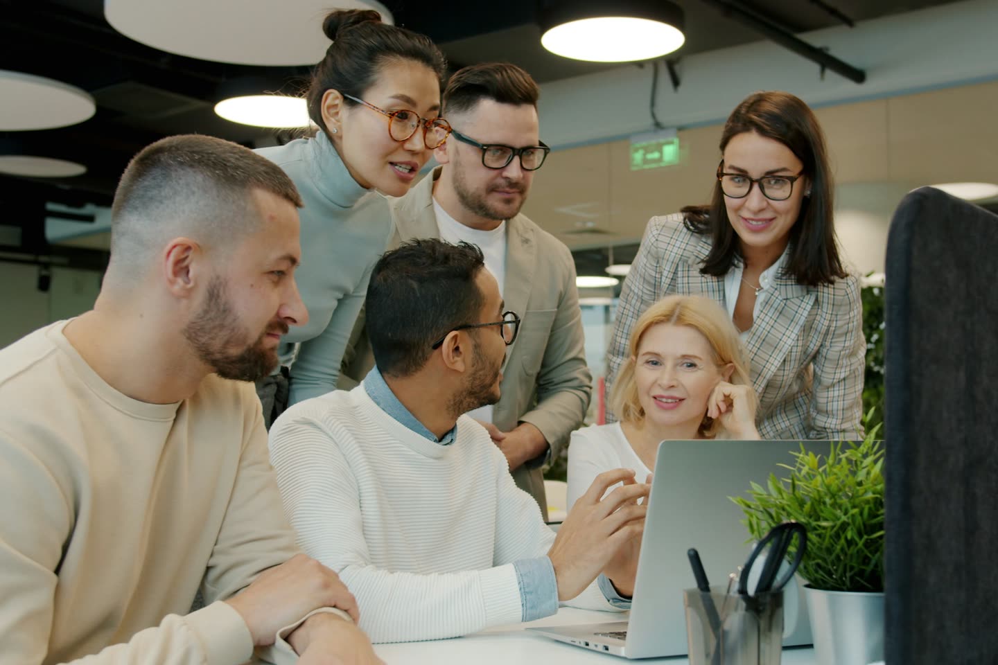 Equipe reunida em volta de um notebook, conversando e sorrindo